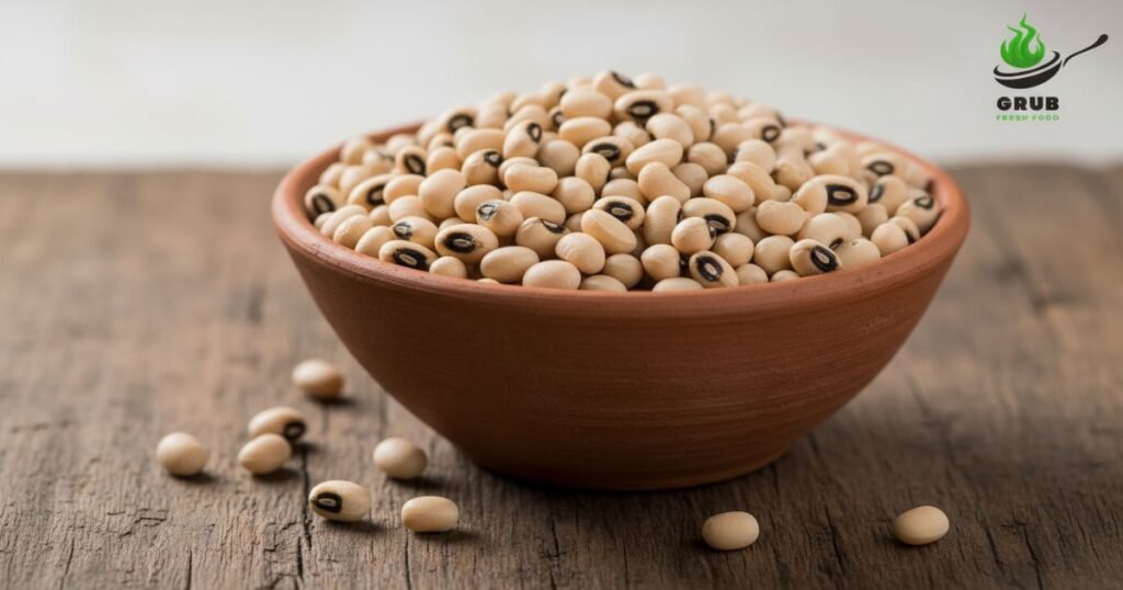 Uncooked black-eyed peas (chowli) in a bowl on wooden surface.