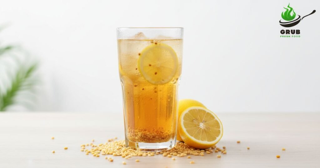 Glass of lemon malt with malt grains and sliced lemon on a white background